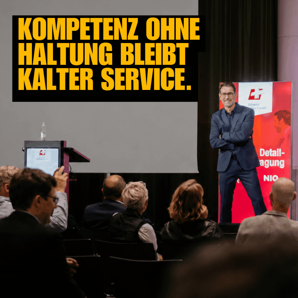 Peter Kreuz hält einen Vortrag auf einer Bühne zum Thema Unternehmenskultur und Service.